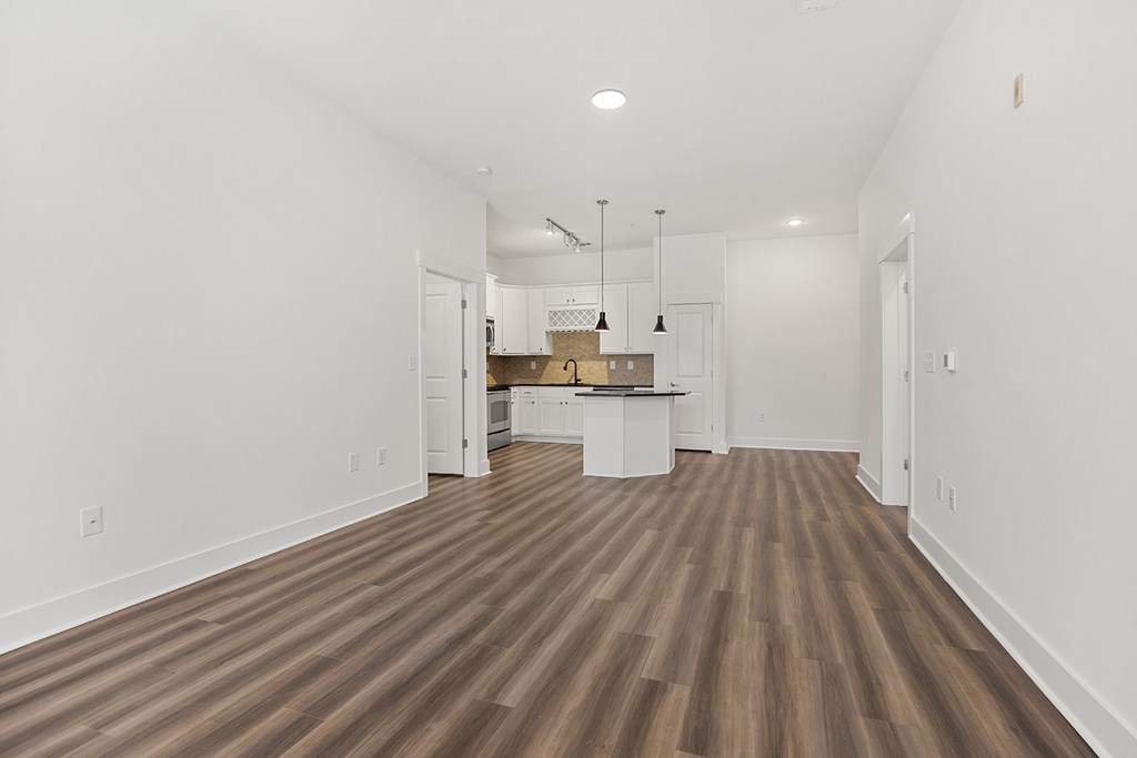 A room with wooden flooring and white walls.