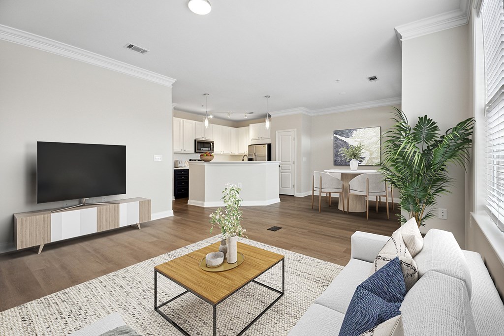A living room with a white couch and a wooden coffee table.