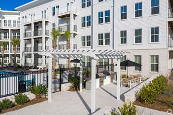 A white building with a pool and a patio area.