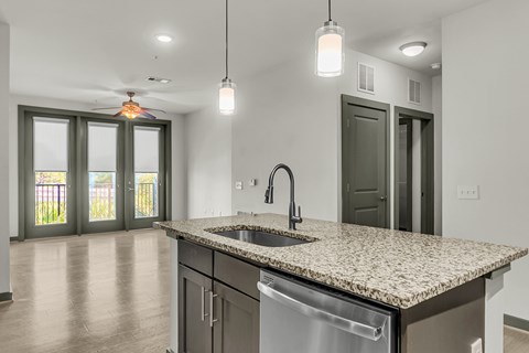 A kitchen with a granite countertop and stainless steel appliances.