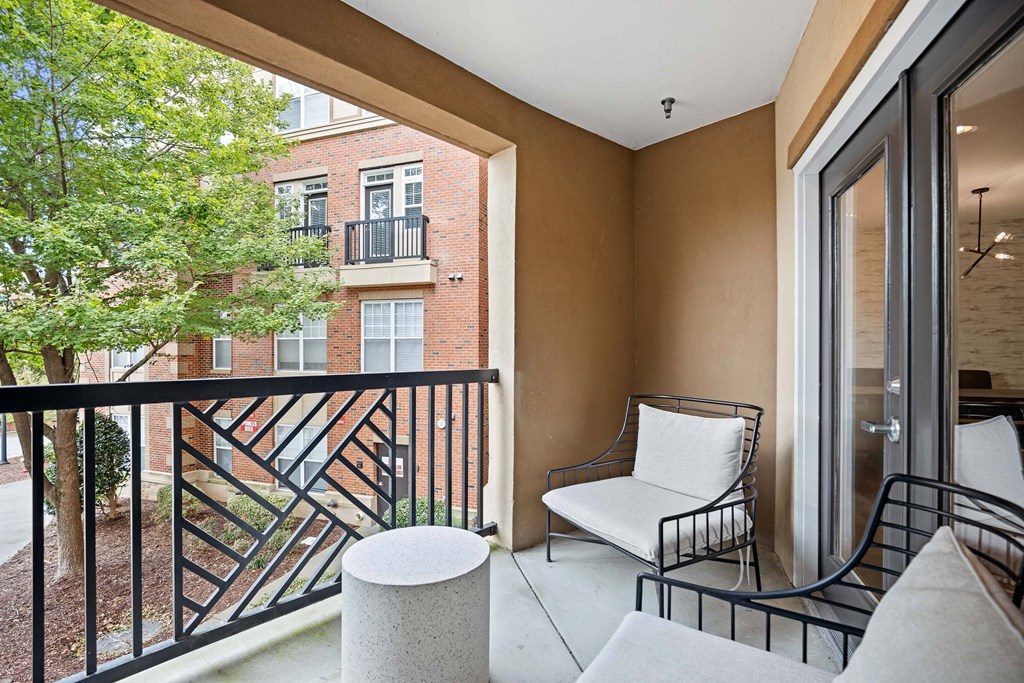 A balcony with a white chair and a black railing.