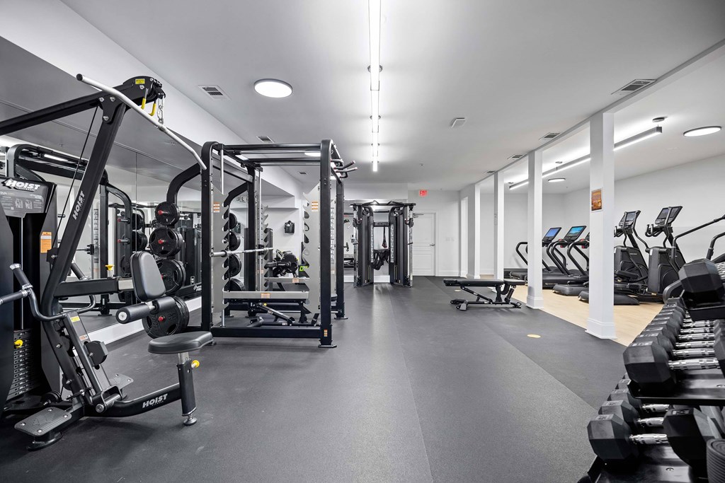 A gym with a variety of equipment including weight machines and free weights.