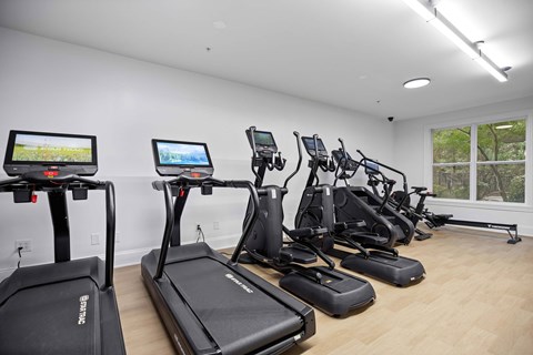 A gym with treadmills and elliptical machines.