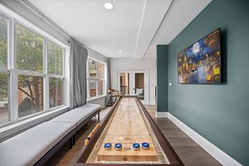 A room with a long table and a painting on the wall.