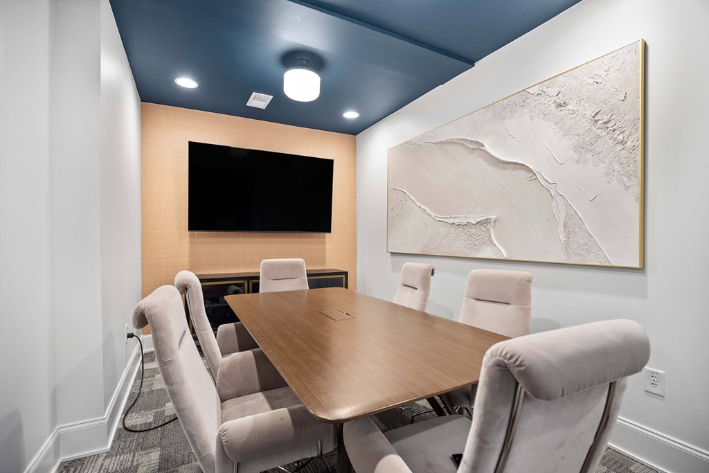 A conference room with a large table and chairs.