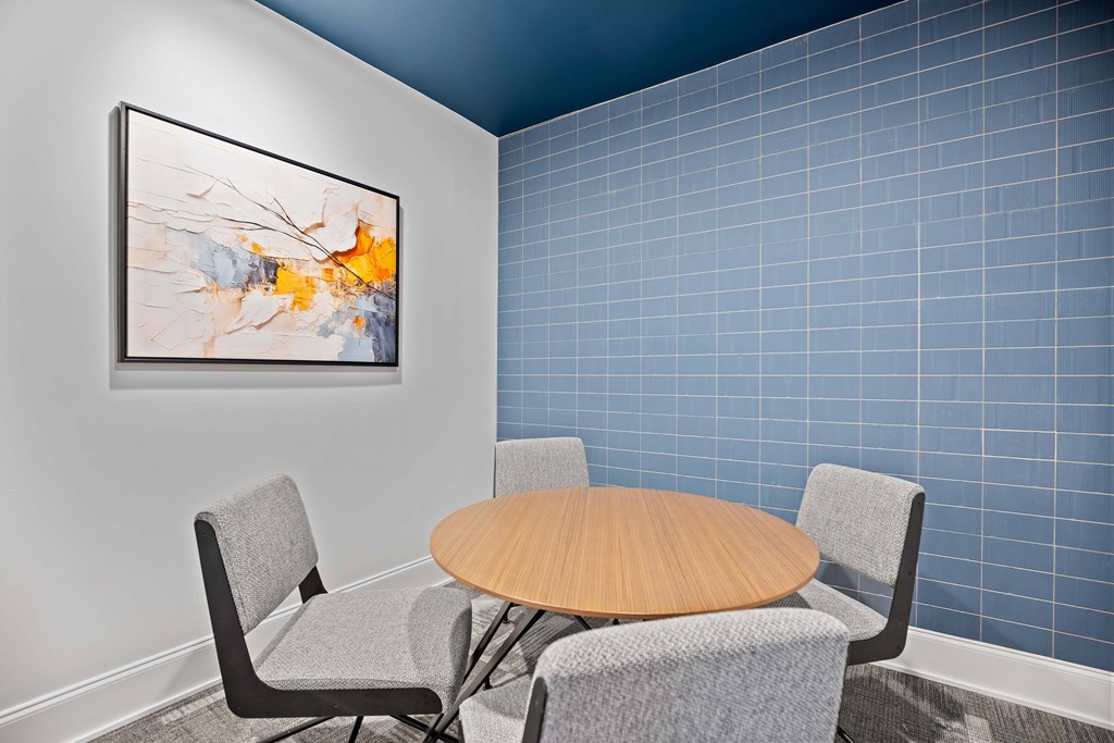 A modern dining room with a round table and grey chairs.