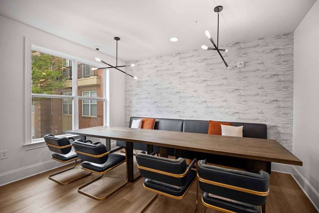A white brick wall with a wooden table and chairs in front of it.