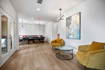 A living room with a glass table and yellow chairs.
