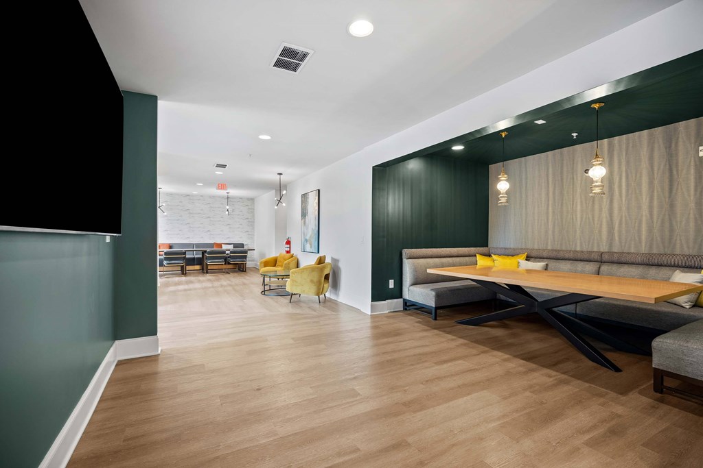 A modern living room with a long wooden table and yellow chairs.