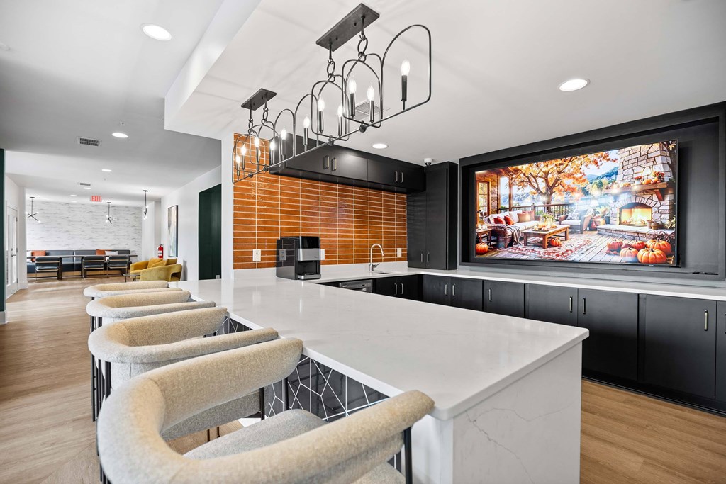 A modern kitchen with a long white island and bar stools.