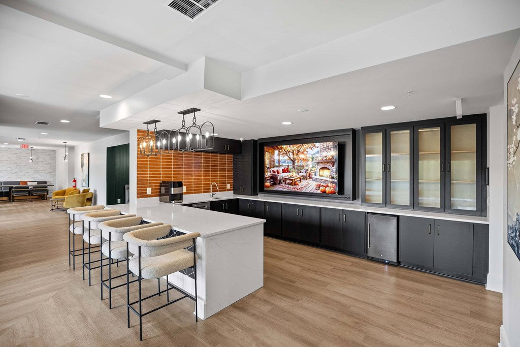 A modern kitchen with a long bar and stools.