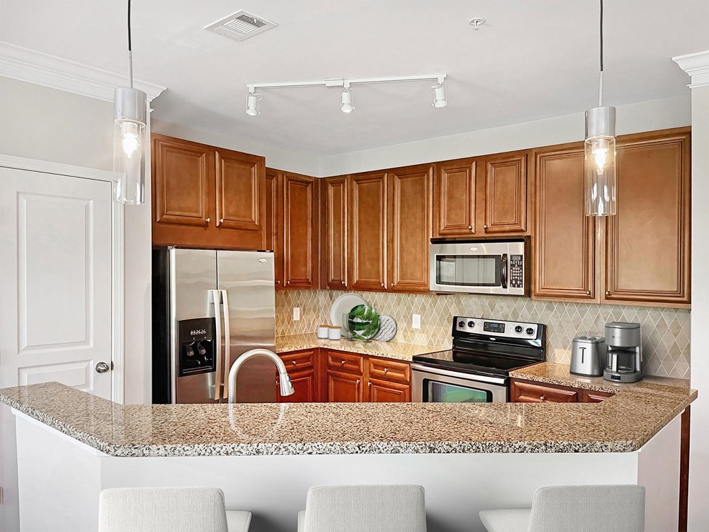A kitchen with wooden cabinets and granite countertops.