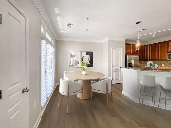 A modern kitchen with a dining table and chairs.