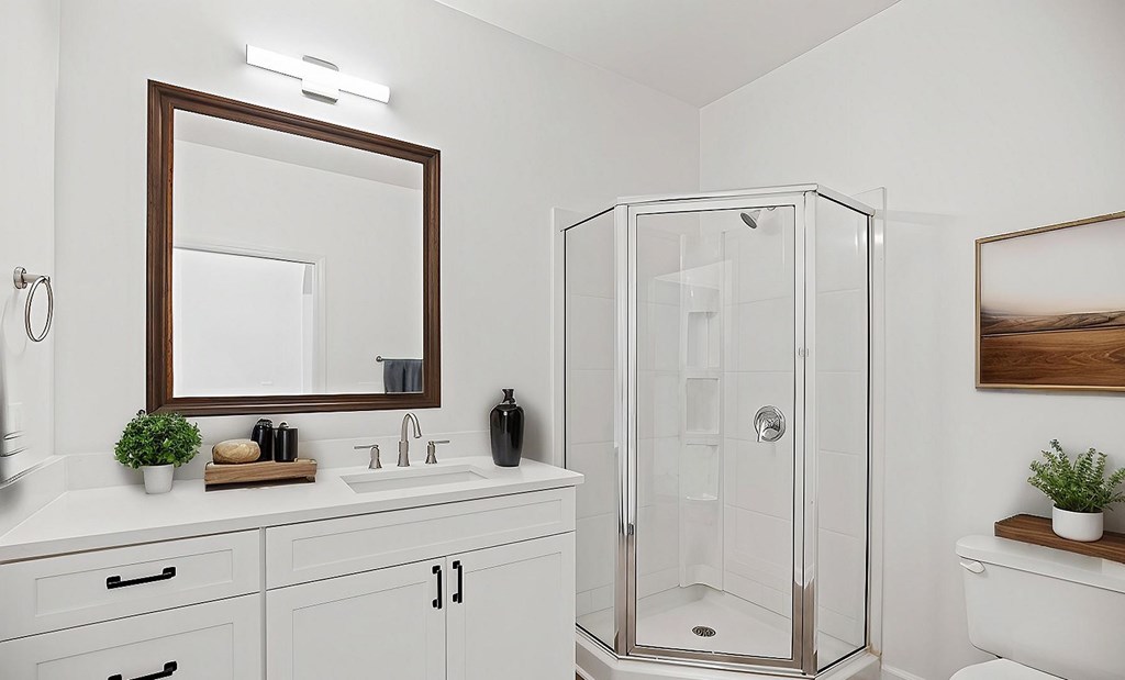A white bathroom with a mirror, sink, and shower.