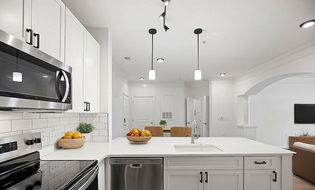 A modern kitchen with a stainless steel oven and a white countertop.