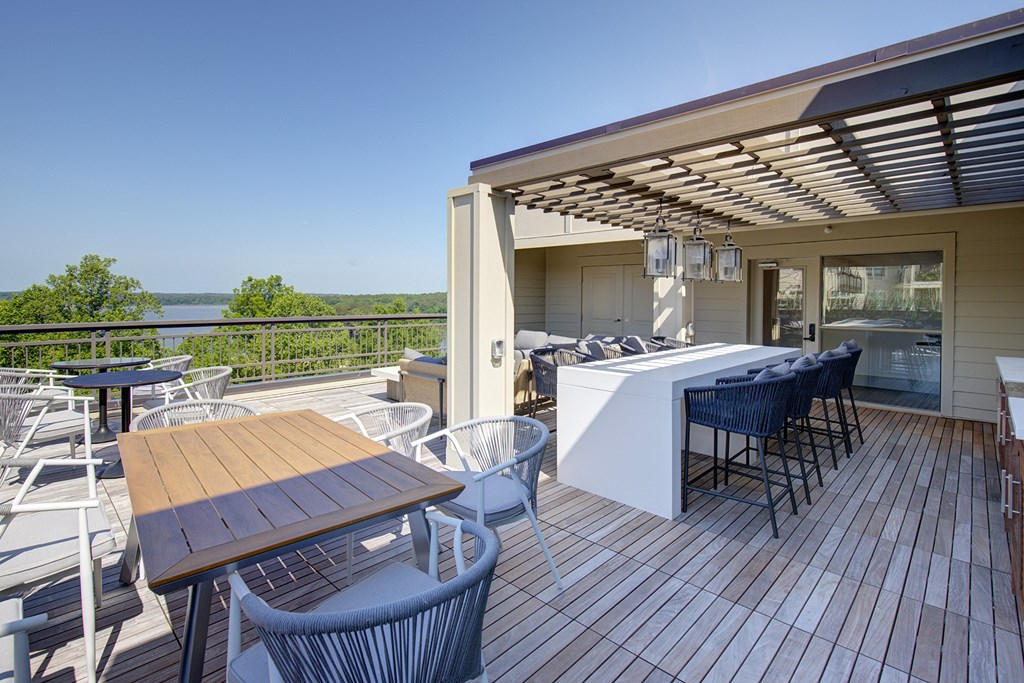 A wooden deck with a table and chairs overlooking a body of water.