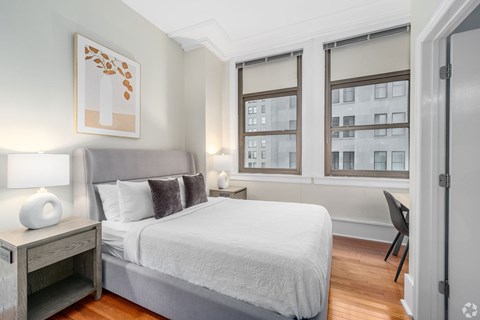 A bedroom with a large bed and a chair.