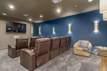 A row of brown leather recliner chairs are lined up in a room with a grey carpet.
