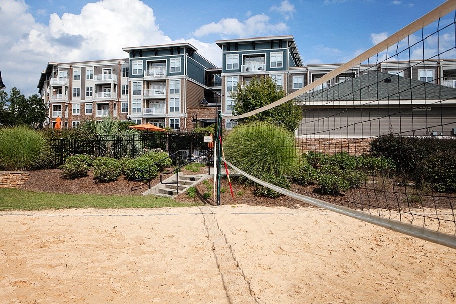 A volleyball net is set up on a sandy court.
