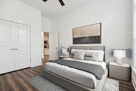 A bedroom with a large bed and a ceiling fan.