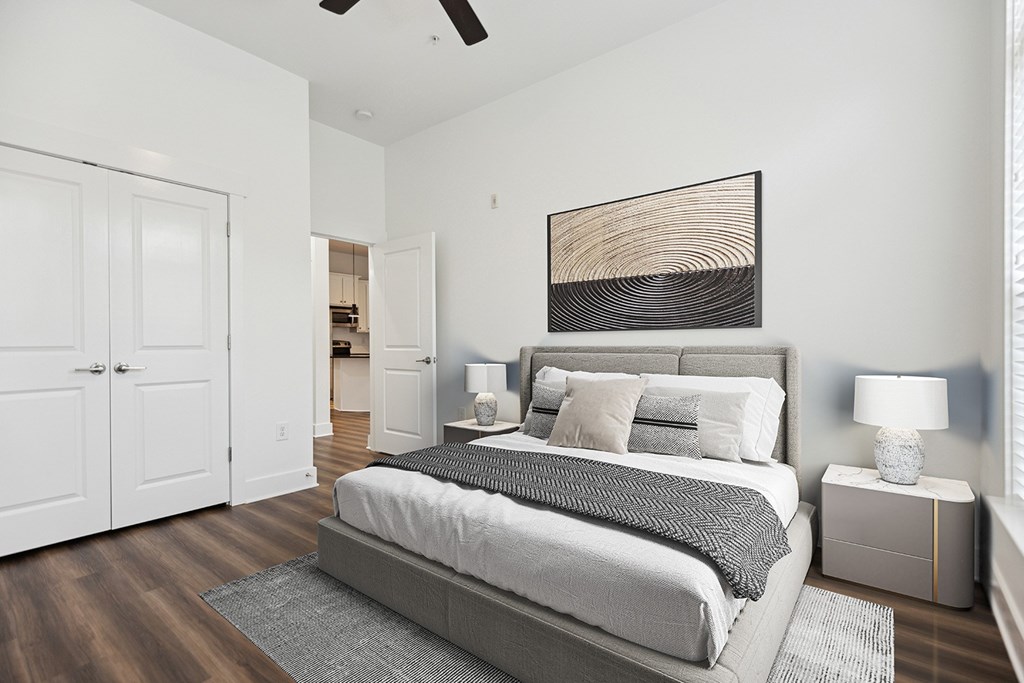 A bedroom with a large bed and a ceiling fan.