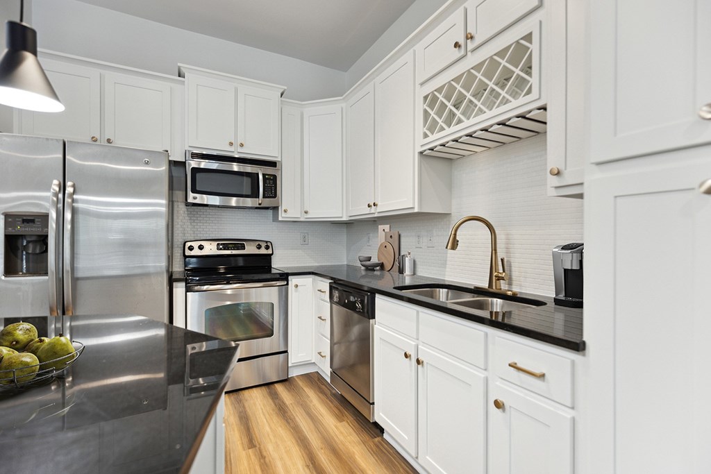 A modern kitchen with white cabinets and stainless steel appliances.