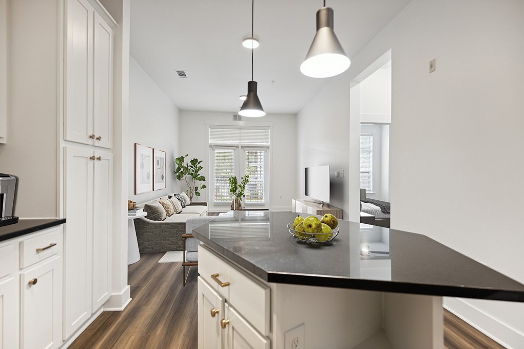 A modern kitchen with a black countertop and white cabinets.
