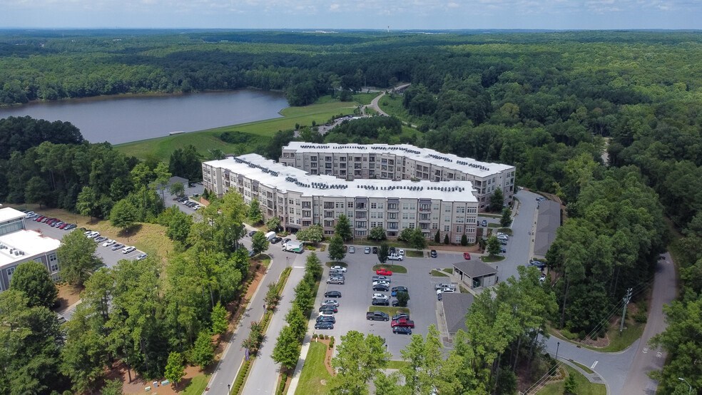 A large white building with a parking lot in front of it.