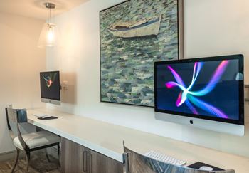 A modern workspace with a large monitor and a smaller screen on the desk.