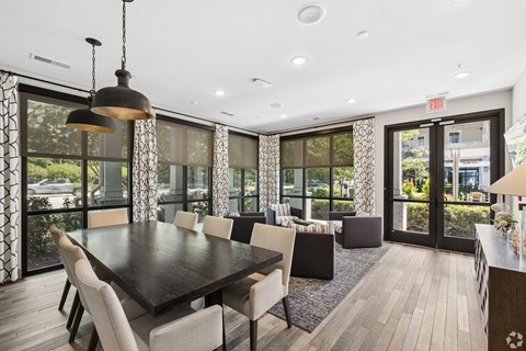 A dining room with a large table and chairs.