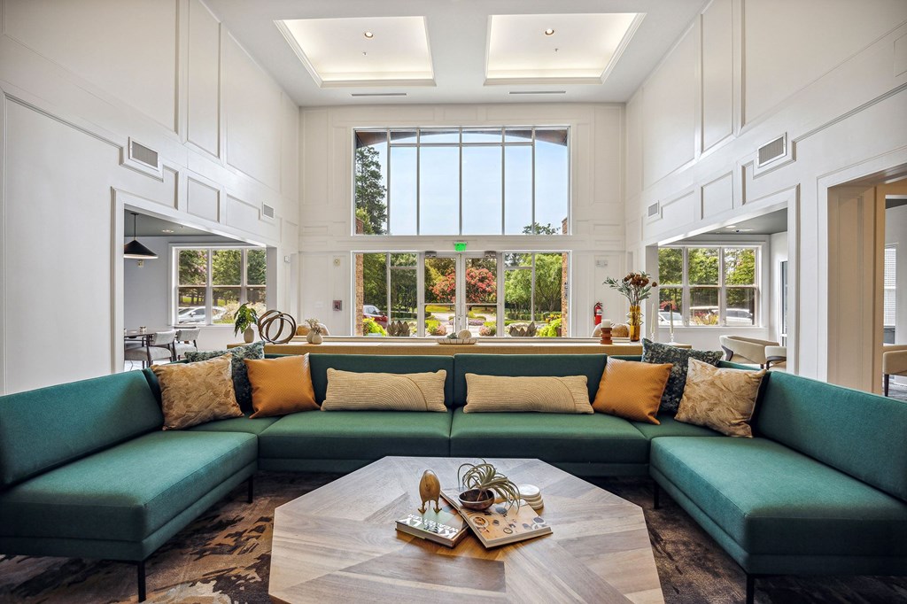 A living room with a green couch and a coffee table in the center.