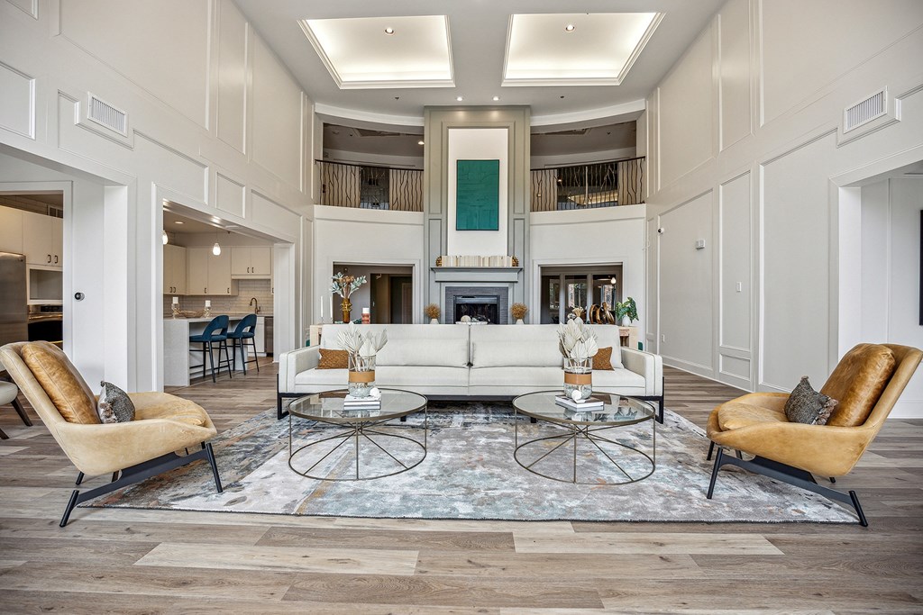 A living room with a white sofa and two chairs.