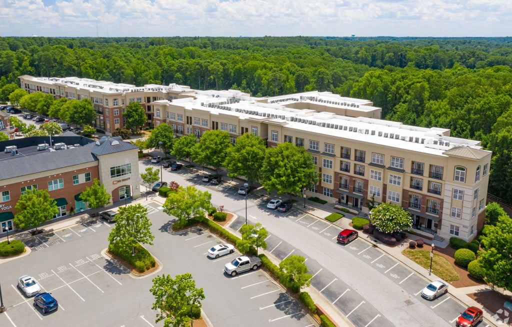A parking lot with cars and a building in the background.