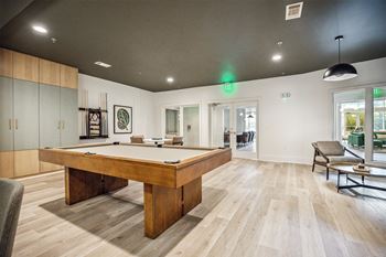 A room with a pool table and a chair.