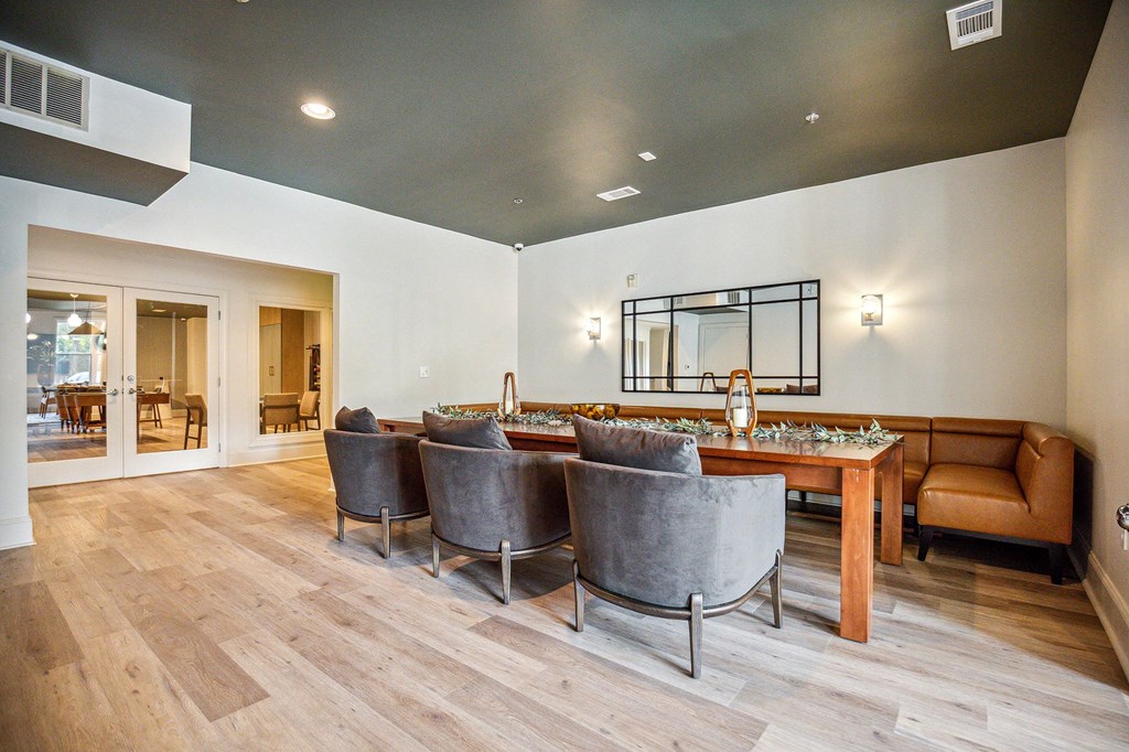 A modern dining room with a long table and grey chairs.