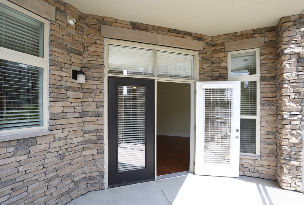 A stone wall with a black door and a white door.