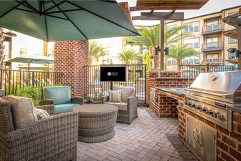 A patio with a grill and seating area.