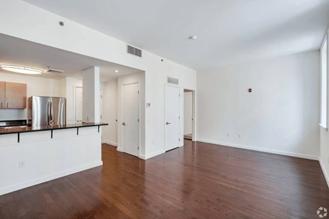 A spacious room with wooden floors and white walls.