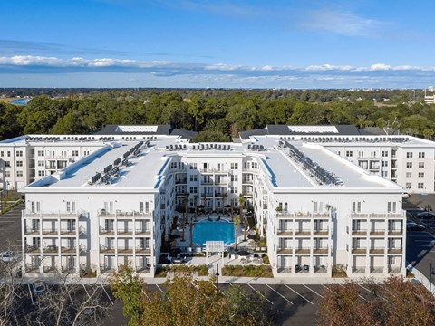 A large white hotel with a pool in the middle of it.