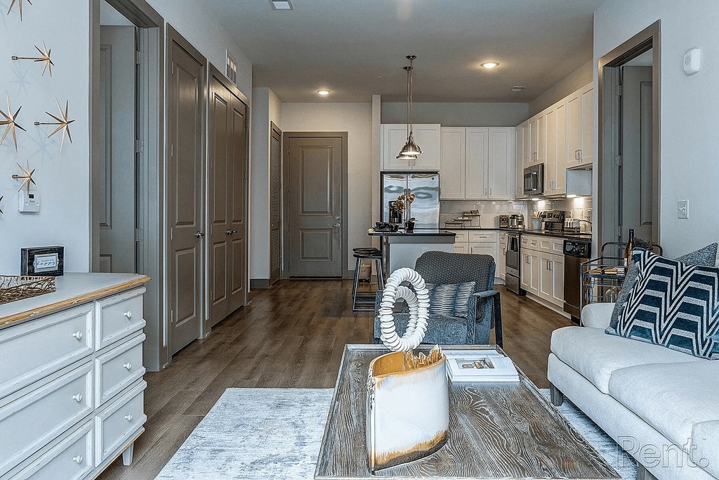 A modern kitchen with a white couch and a wooden floor.