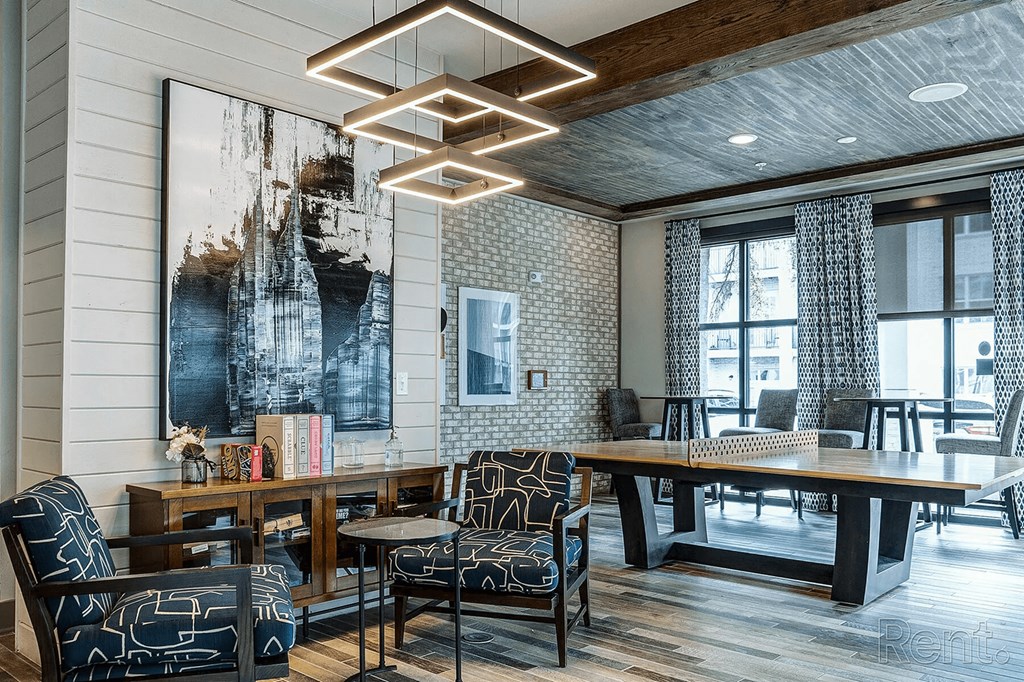 A modern living room with a large abstract painting on the wall and a wooden floor.