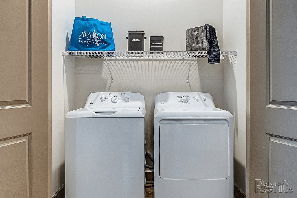 Two white washing machines in a small laundry room.