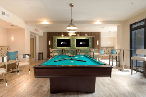 A pool table in a room with a light brown floor.