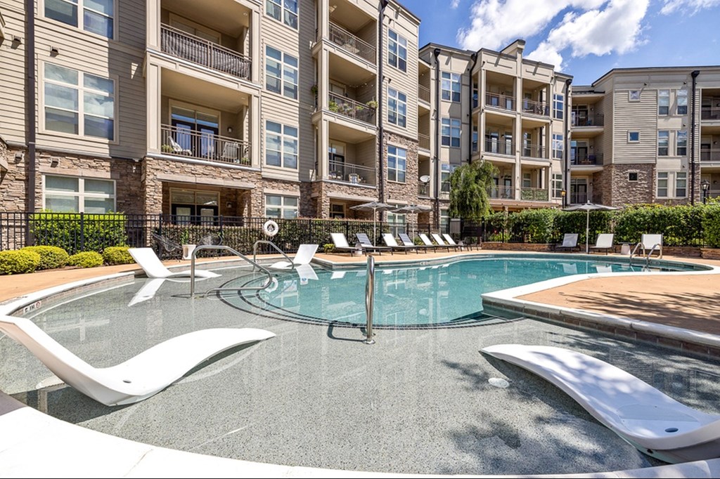 A swimming pool in front of apartment buildings.