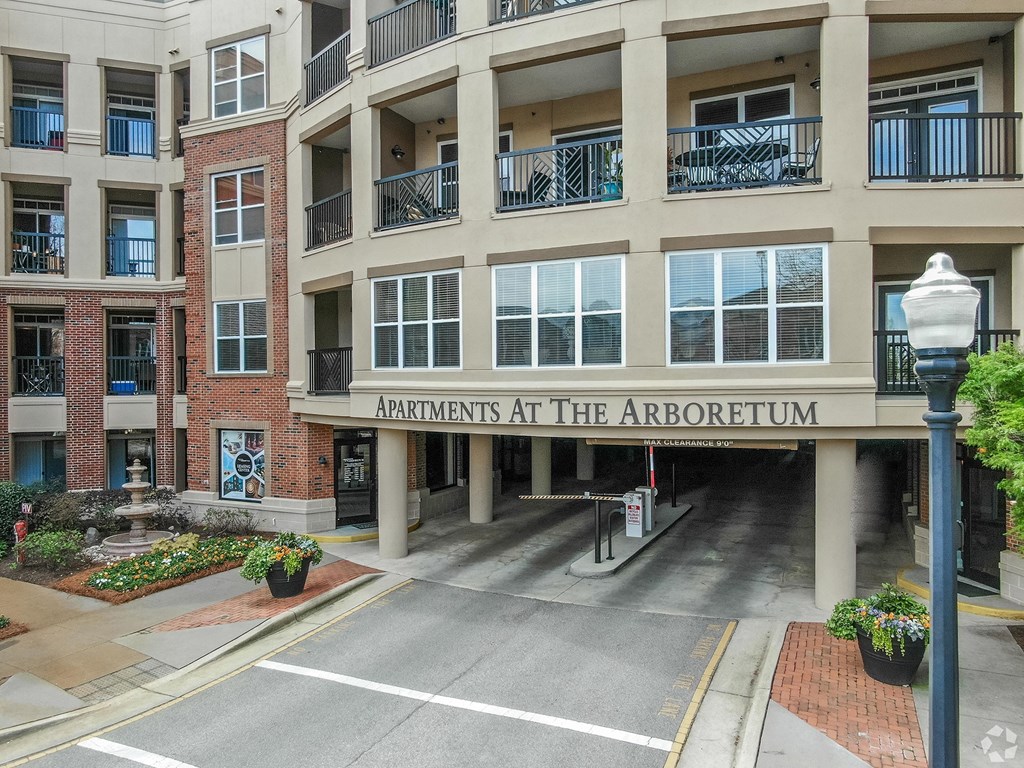 The Arboretum Apartments building has a brick facade and is surrounded by greenery.