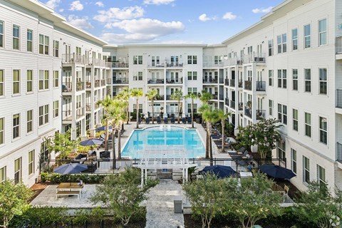 A large white building with a pool in the middle of the courtyard.