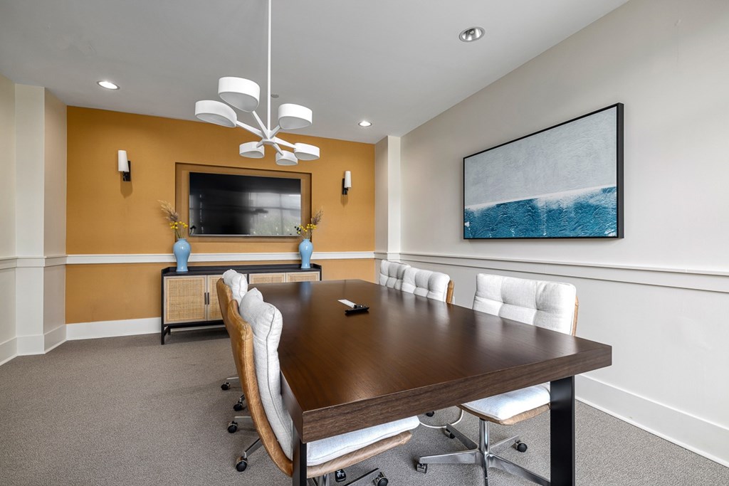 A conference room with a long table and chairs.