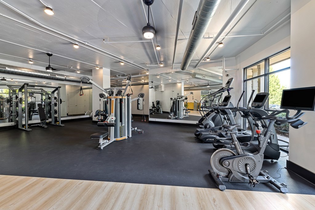 A spacious gym with a variety of equipment including treadmills, weights, and exercise machines.