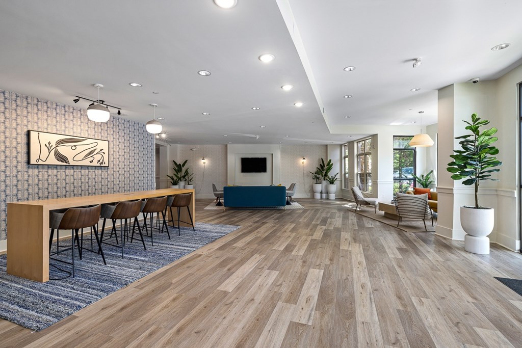 A room with wooden floors and a long table with chairs.