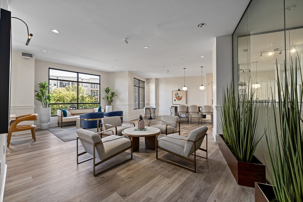 A modern living room with a glass wall and a wooden floor.